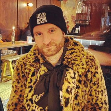paul bonham wears a leopard print coat and black beanie