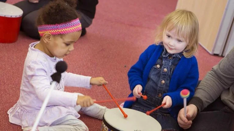 Two children playing drums
