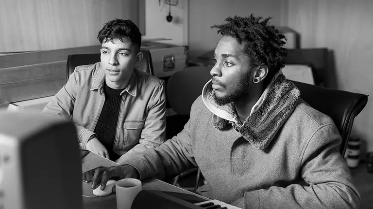Two young people making music on a computer