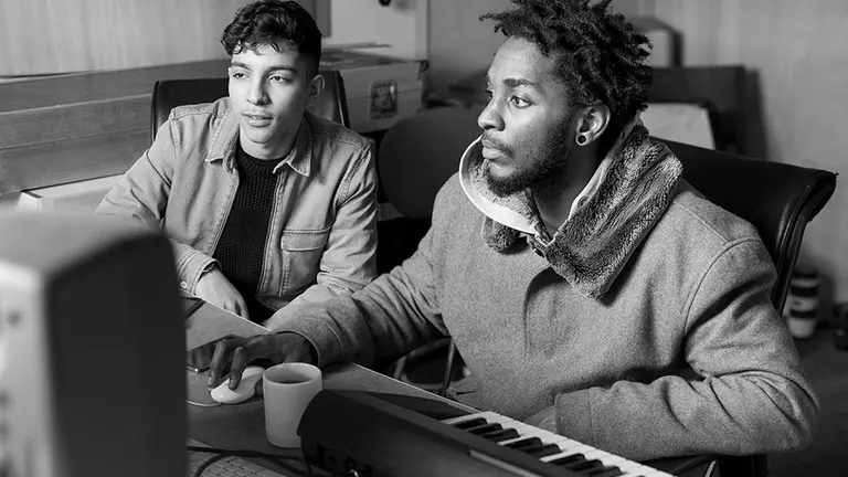 Two young people making music on a computer