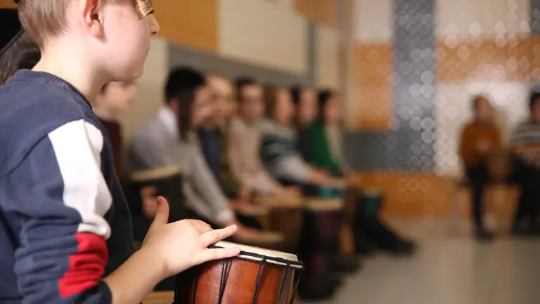 Haredi young children playing small drums in a semi circle