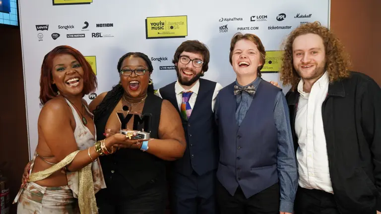 Five winners of the Original Track Award (Group) sponsored by Marshall celebrating the win with the award in their hands
