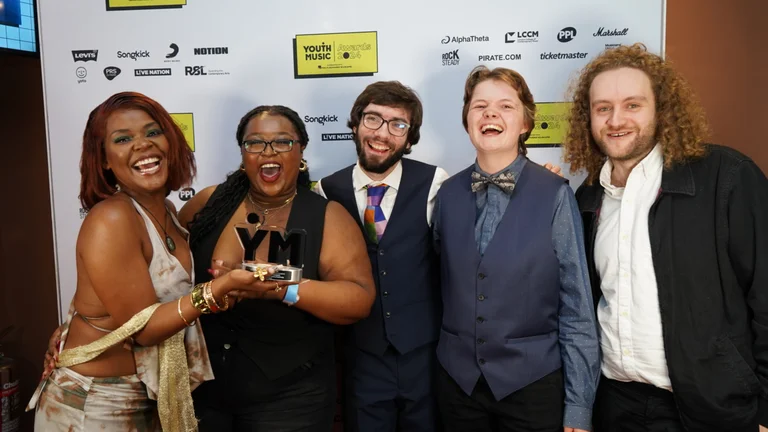 Five winners of the Original Track Award (Group) sponsored by Marshall celebrating the win with the award in their hands