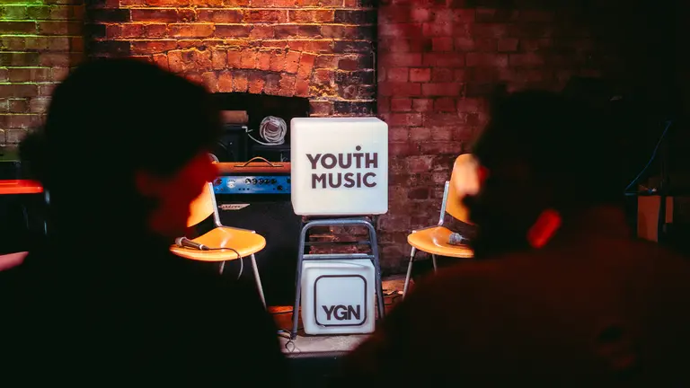 two white boxes are stacked on top of each other. the top box bears youth music's logo and the bottom shows YGN