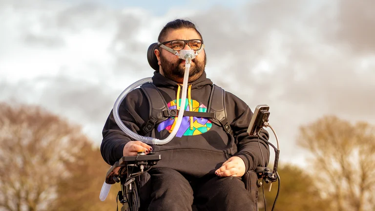 supermann on da beat is pictured in a wheelchair, with an autumn backdrop
