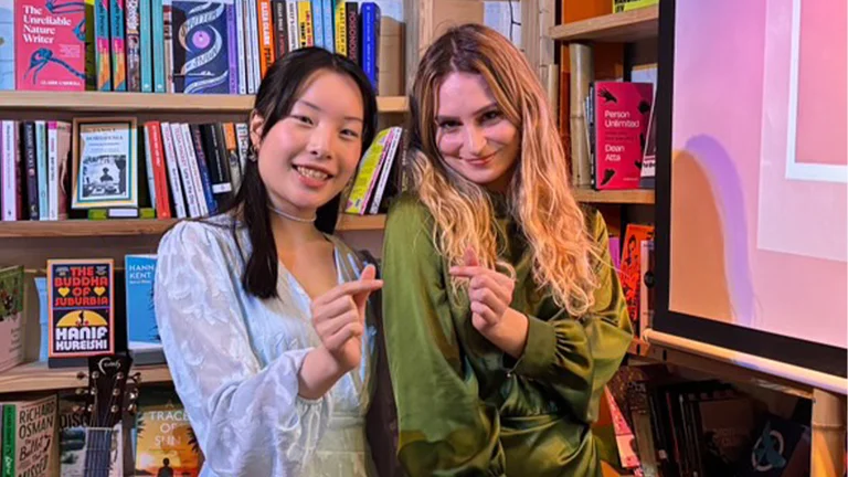 monica wat and cat rose pose together, making heart signs with one hand