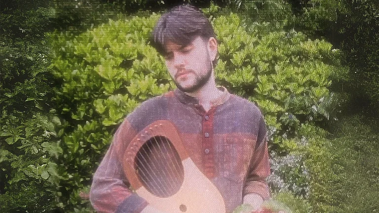 anthony holds a musical instrument in a garden