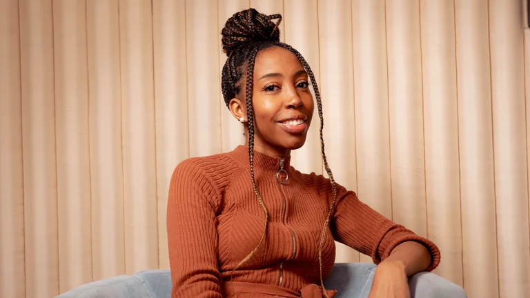 chloe ameh sits in a chair and smiles