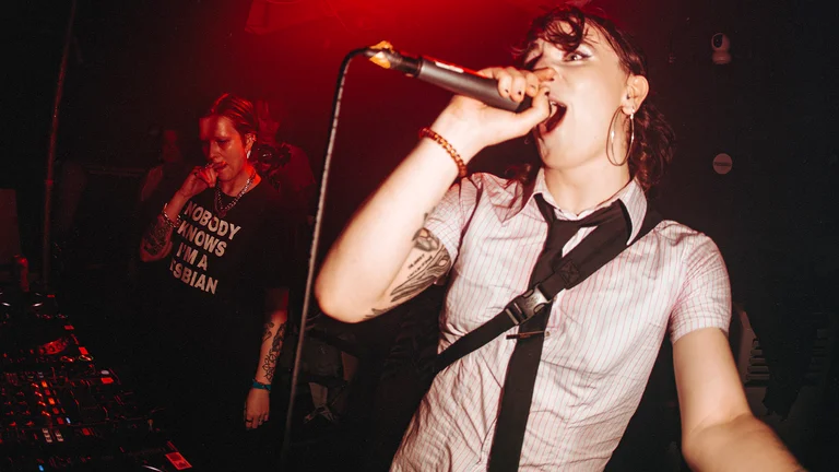 a woman sings into a mic on stage