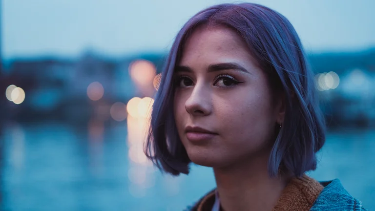 sylvia has a straight bob, and is pictured in front of a river