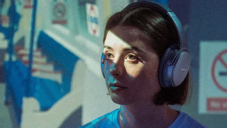 sylvia has brown hair cut in a bob and wears headphones while on the tube