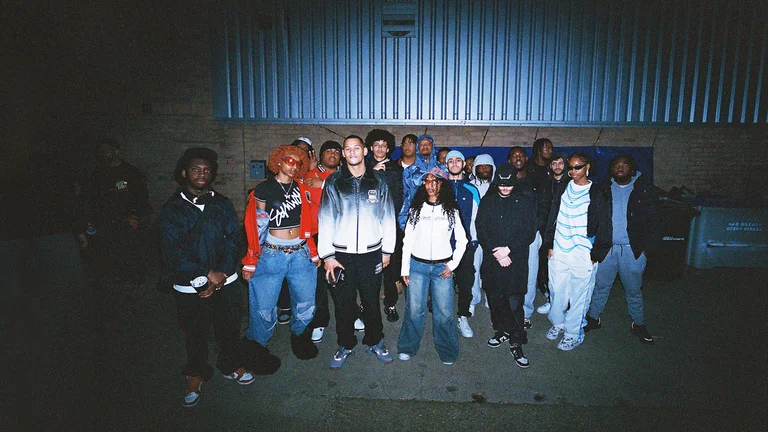 A big group ion young people in a dark street illuminated by the camera flash