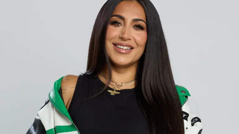 image of ellie prohan, jacket off one shoulder and smiling
