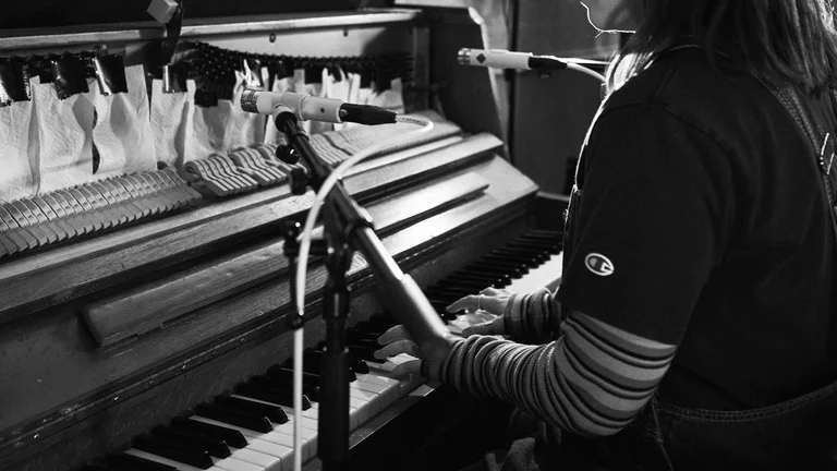 a person sits at a piano and plays