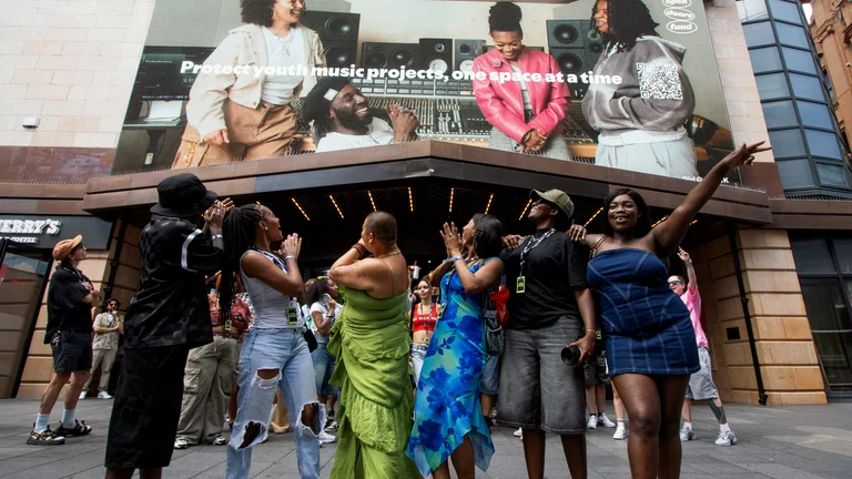 image of the girls from girl grind uk reacting to seeing their advert above the spotify offices