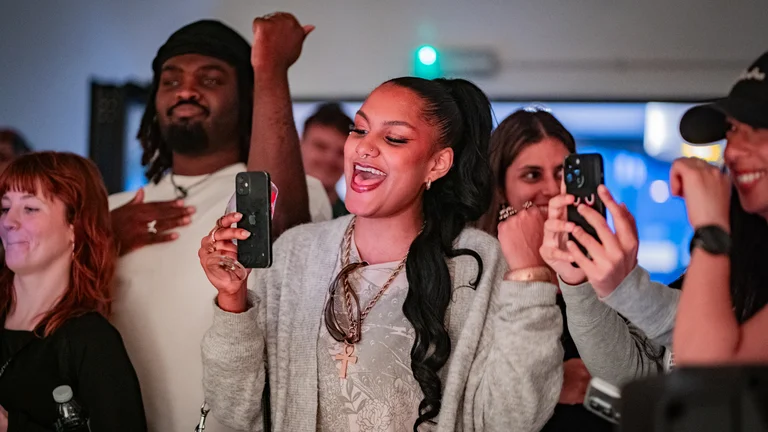group of young people dancing and singing along to a live performance