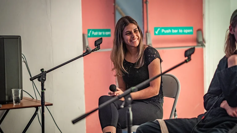 talia andrea is sitting on a chair and smiling