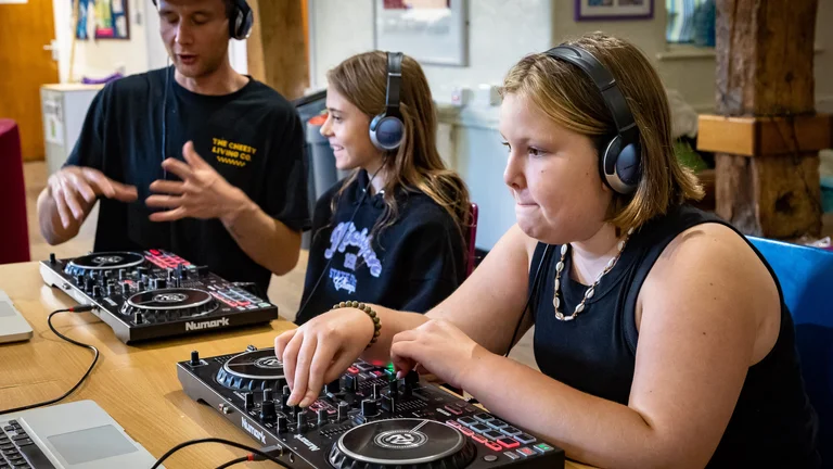Young people learning how to use DJ decks
