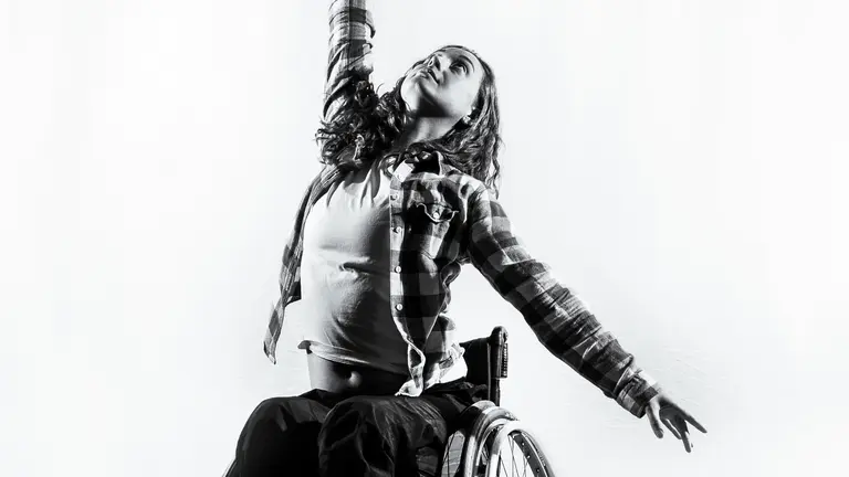 black and white image of Lauren in a dancing pose in a wheelchair