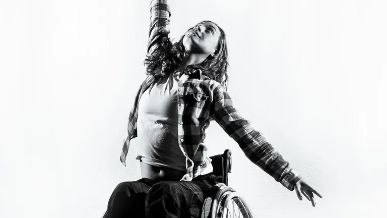 black and white image of Lauren in a dancing pose in a wheelchair