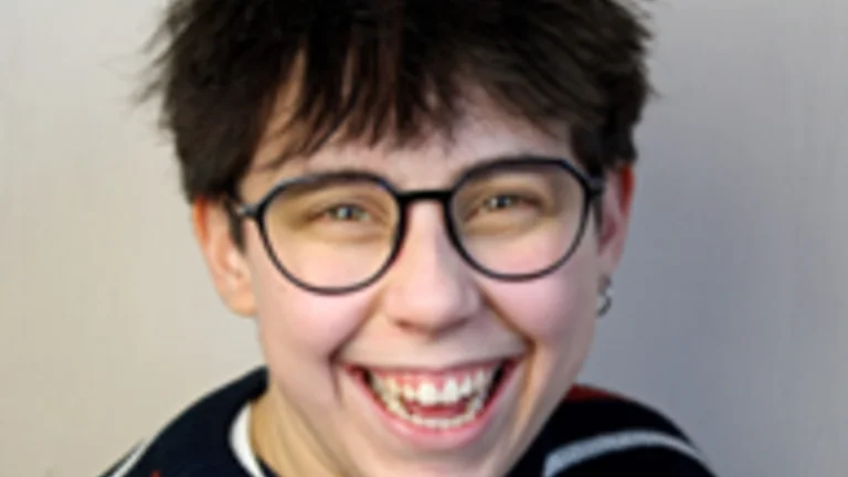 headshot of Lou smiling wearing glasses and a stripey jumper