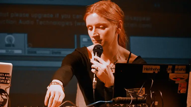 A young person DJs whilst talking into the mic