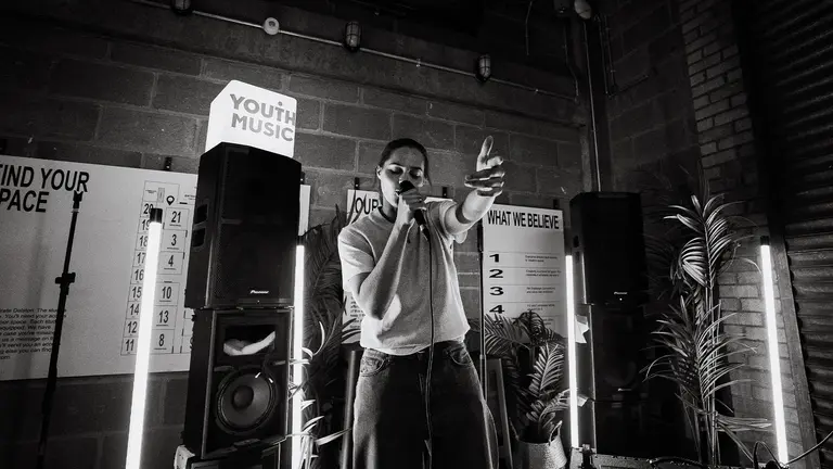 IBack performs into a mic 