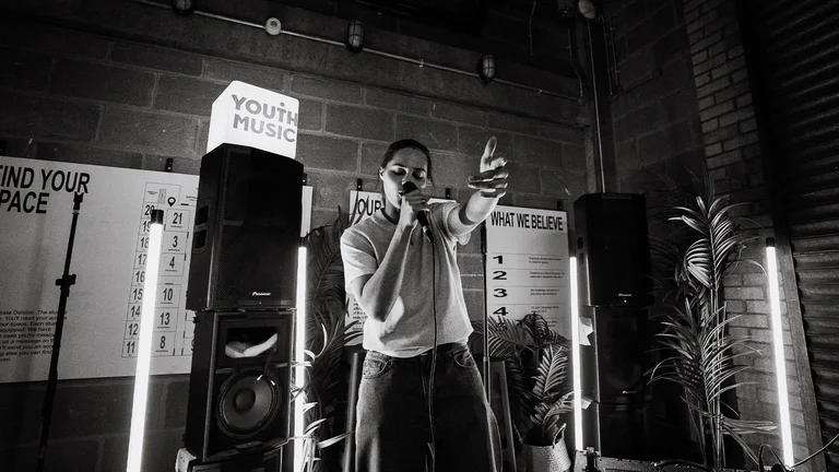 IBack performs into a mic 