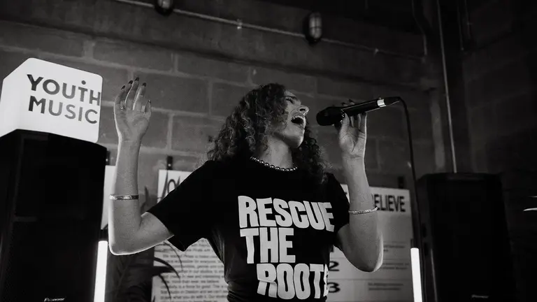 livvy k sings passionately into a mic