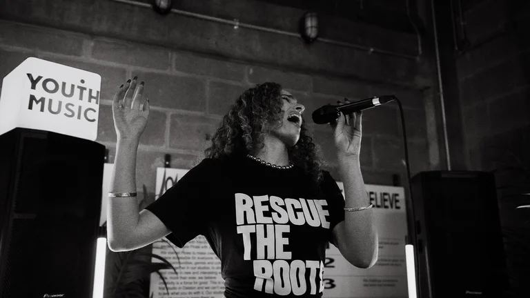 livvy k sings passionately into a mic