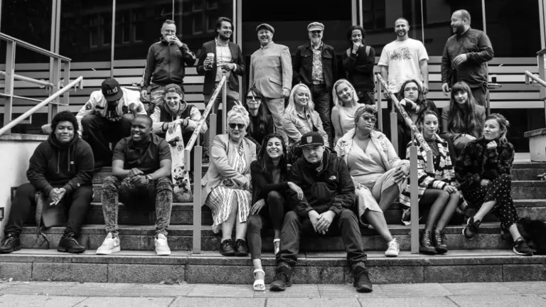 offshoots team and participants gathered on stairs outside in black and white