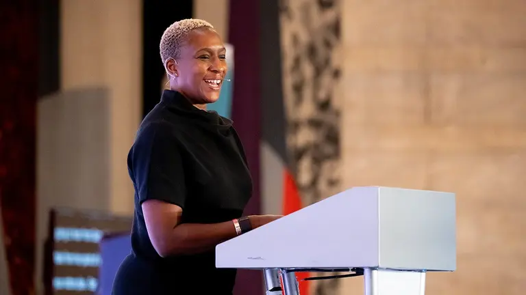 Black woman speaker smiling from the stage