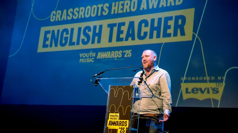 ENglish teacher winning the grassroots hero award at the YMAs2025