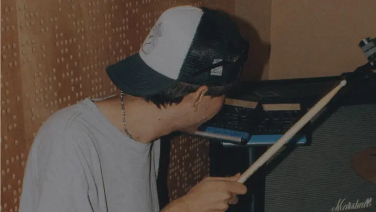 Young person with a cap and a drum stick
