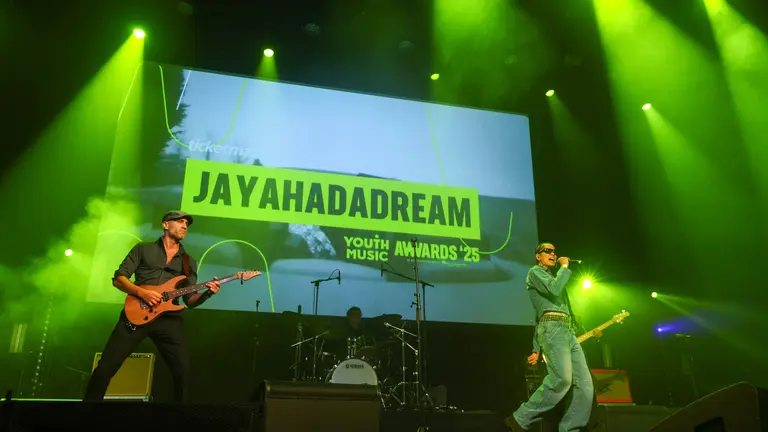 jayahadadream performing on stage at the Youth Music Awards 2025, green lights flooding the stage