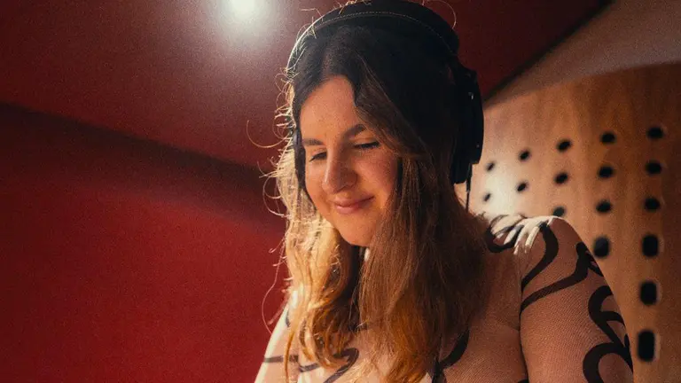 dj grace looks down with headphones on