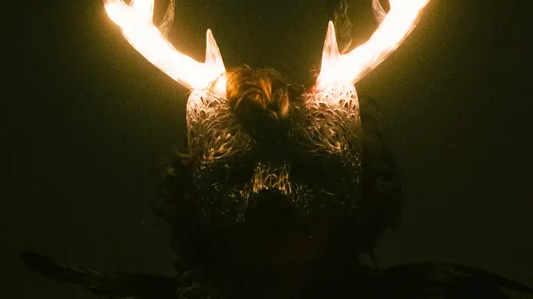 a masked person has glowing horns