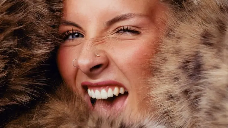 a woman's face photographed up close surrounded by a fur coat