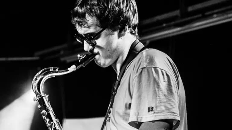 a black and white photo of a man playing a saxophone