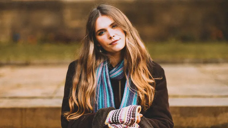 lottie has long blonde hair and wears a scarf