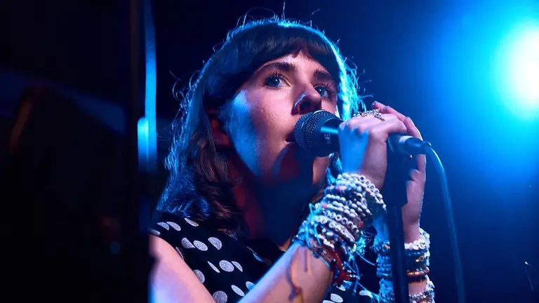 a woman with brown hair grips a microphone