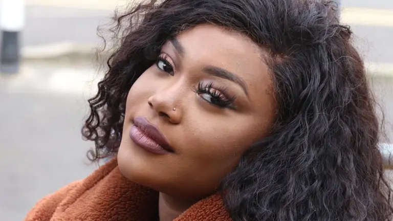 a woman with wavy hair looks at the camera