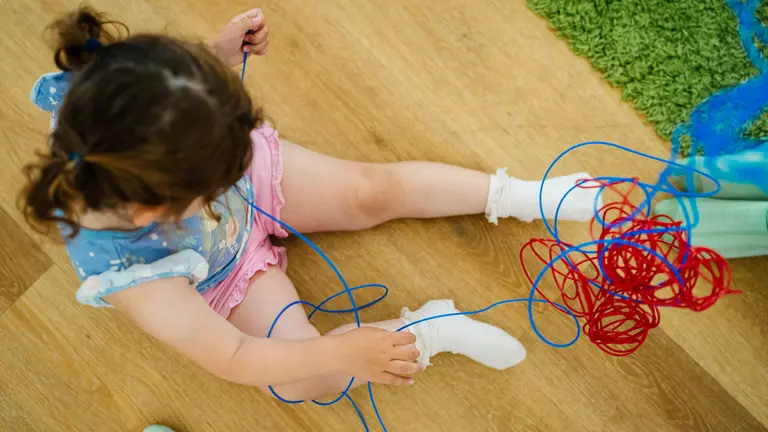 Child playing with sensory toy wearing pink and blue 