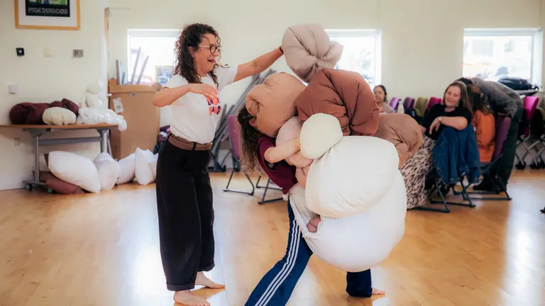 two adult practitioners playing with pillows and bean bags
