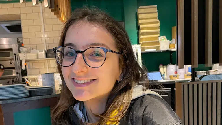 Ruby inside a restaurant, smiling at the camera
