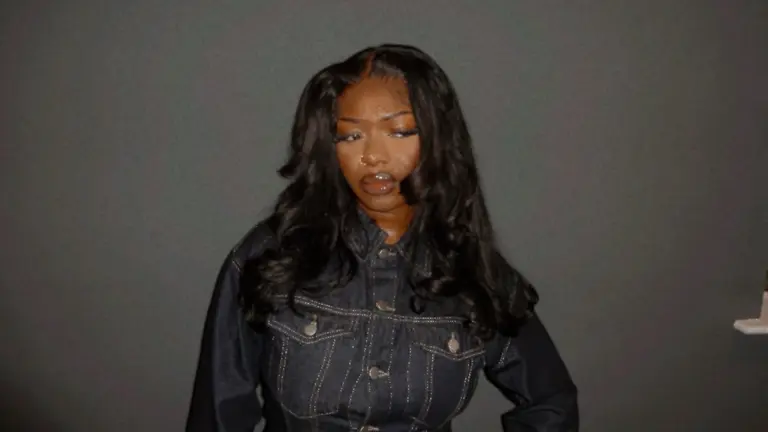 Tobi Zoe standing against a dark grey background looking at the camera