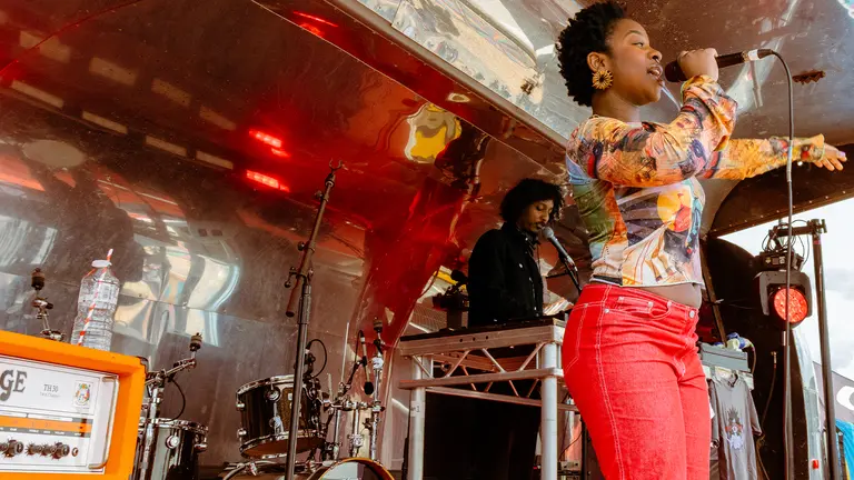 meduulla holds a mic in her hand and sings on stage