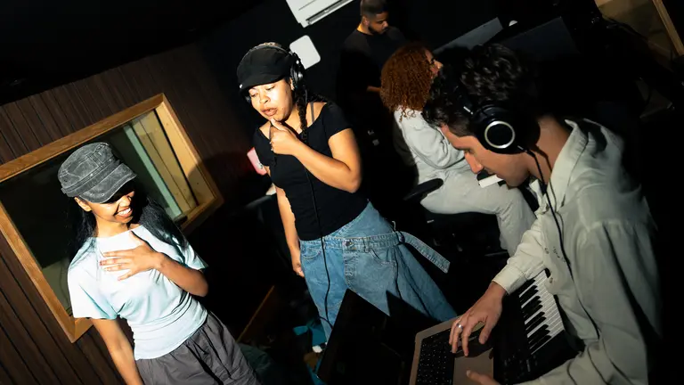 Young artists in a studio, two singers and one person on the midi keyboard