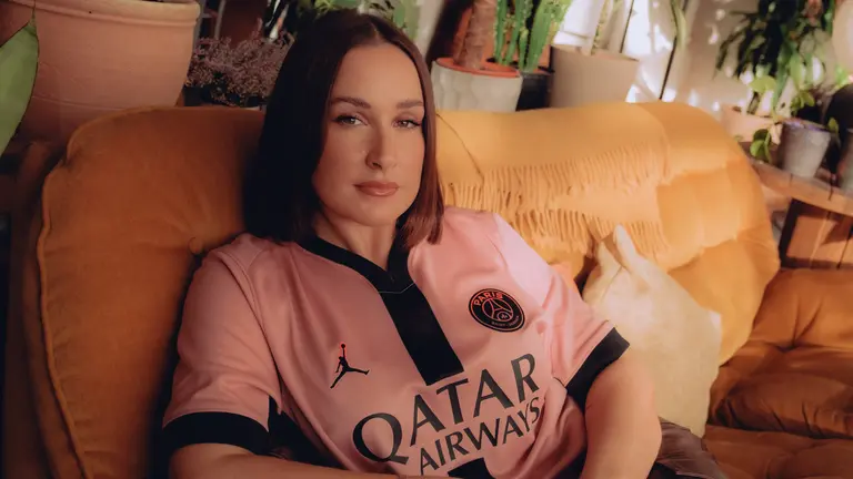 Kennedy Taylor headshot, on a sofa wearing a PSG top
