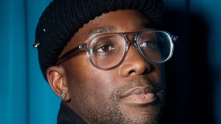 Yaw headshot, wearing a beanie and clear-rimmed glasses
